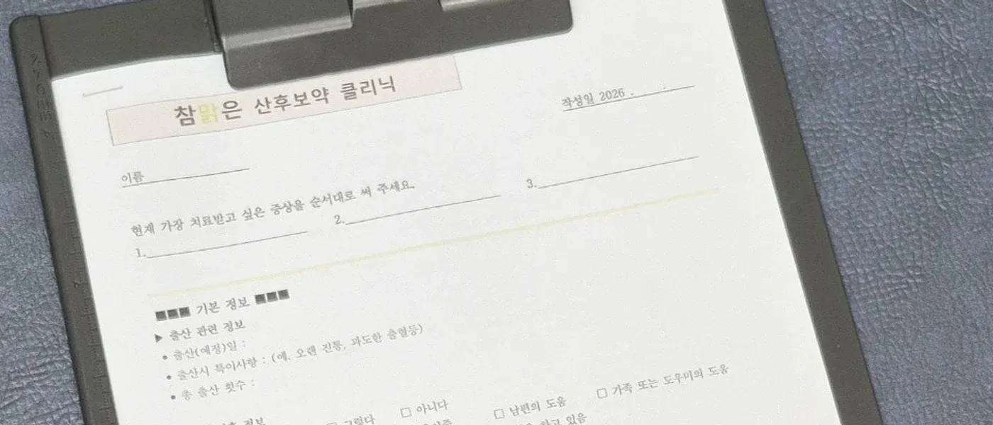 ‘참맑은 산후보약 클리닉’ 제목의 문진 설문지가 클립보드에 끼워져 있고 볼펜이 놓인 모습